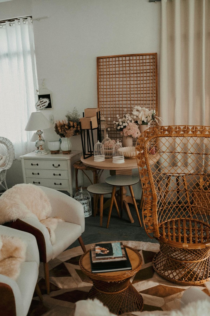 A bohemian-style living room with a rattan peacock chair and armchair instead of a traditional sofa