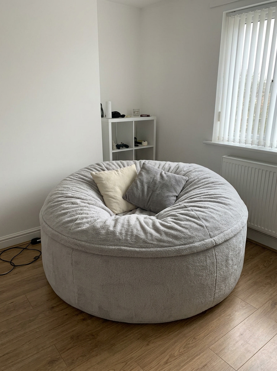 A 6ft Cosac in ash sherpa fleece set up as a reading corner with a throw blanket and warm side lamp