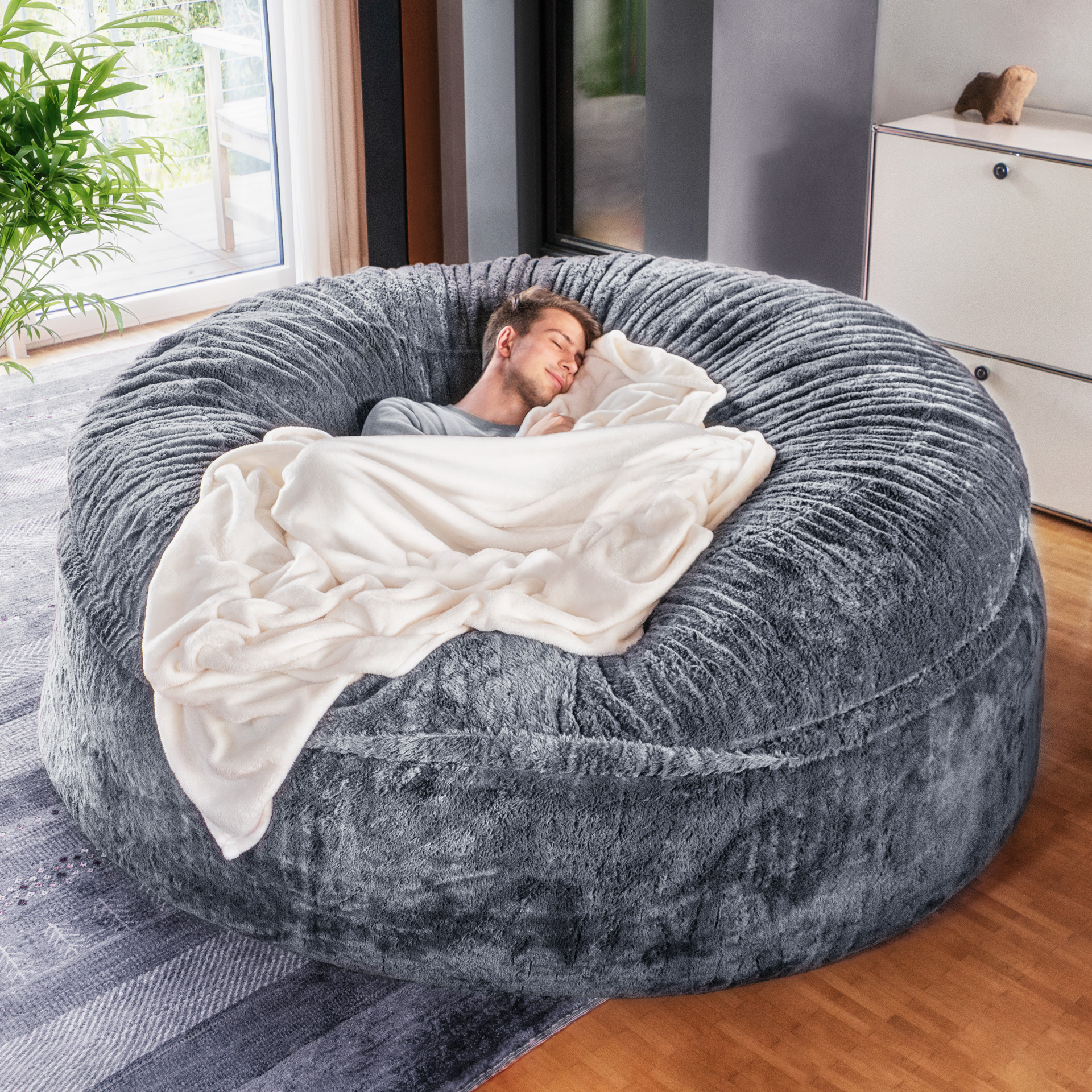 Man napping on The Cosac with a blanket